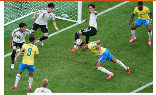 Brazil attacker attempts a diving header against Japan defenders inside the penalty area